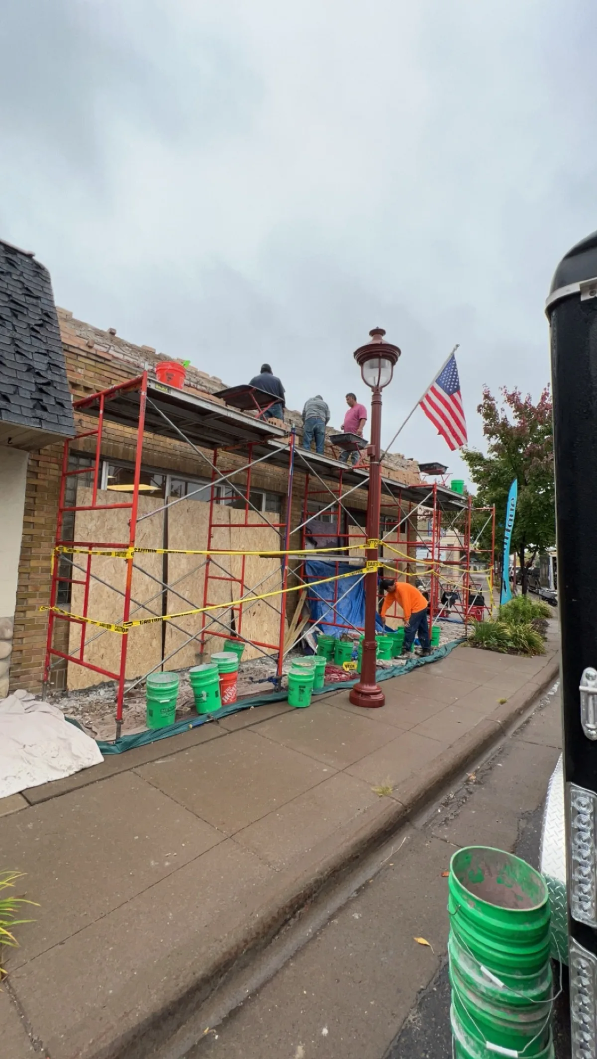 Storefront parapet rebuild in progress behind scaffolding